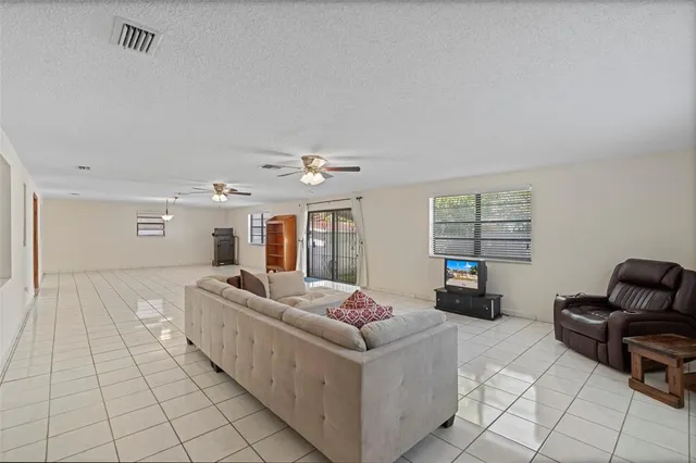 a view of a livingroom with wooden floor and a ceiling fan