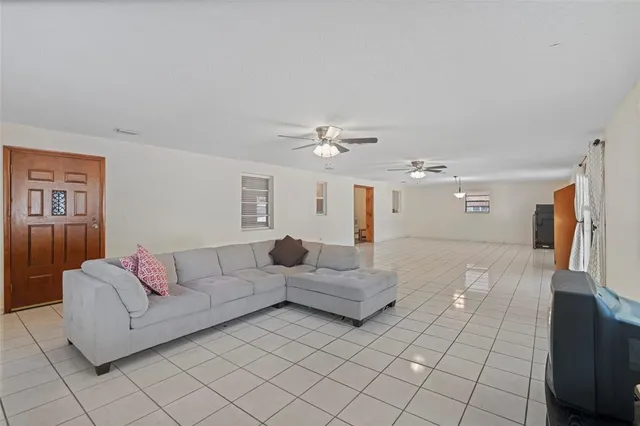 a view of a hallway with wooden floor and a living room
