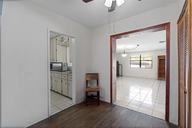 a view of empty room with window ceiling fan and refrigerator