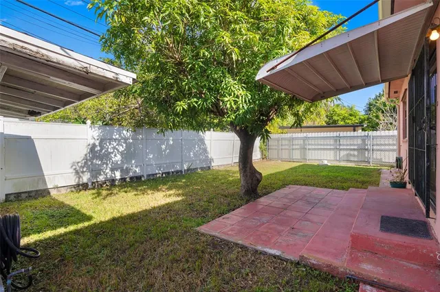 an aerial view of a house with a yard and large tree