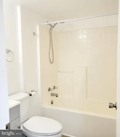 a white toilet sitting next to a bath tub and a shower
