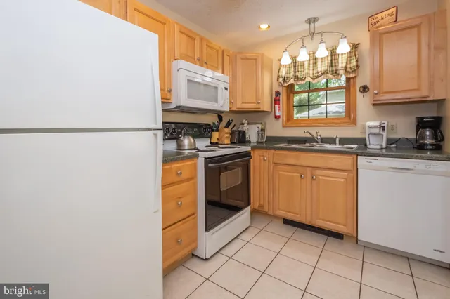 a kitchen with a sink a stove top oven and white stainless steel appliances