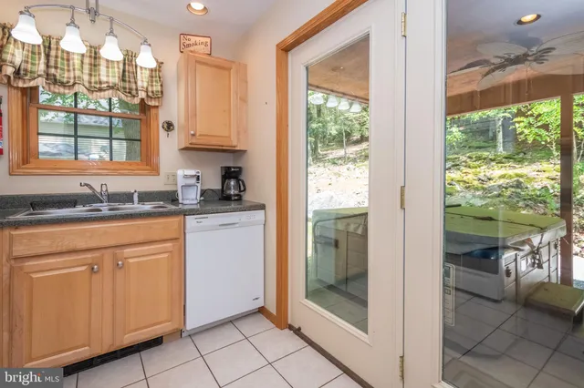 a kitchen with granite countertop a refrigerator a sink and white cabinets