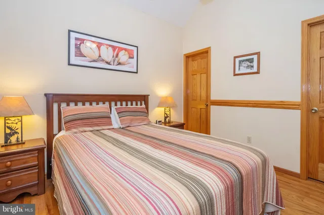 a bedroom with bed and paintings on the wall