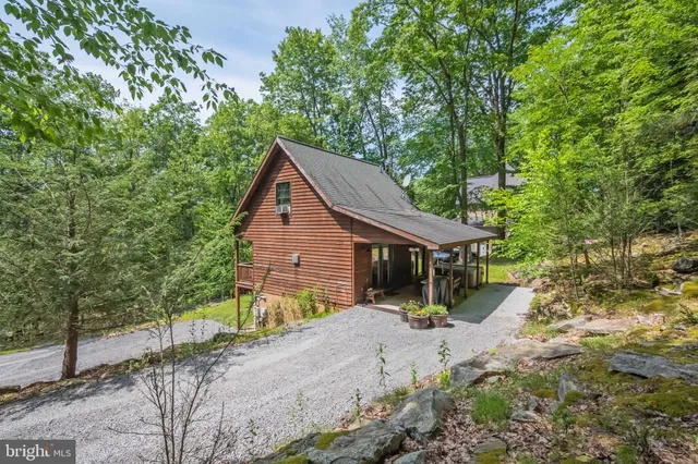 a view of a house with a yard and large tree