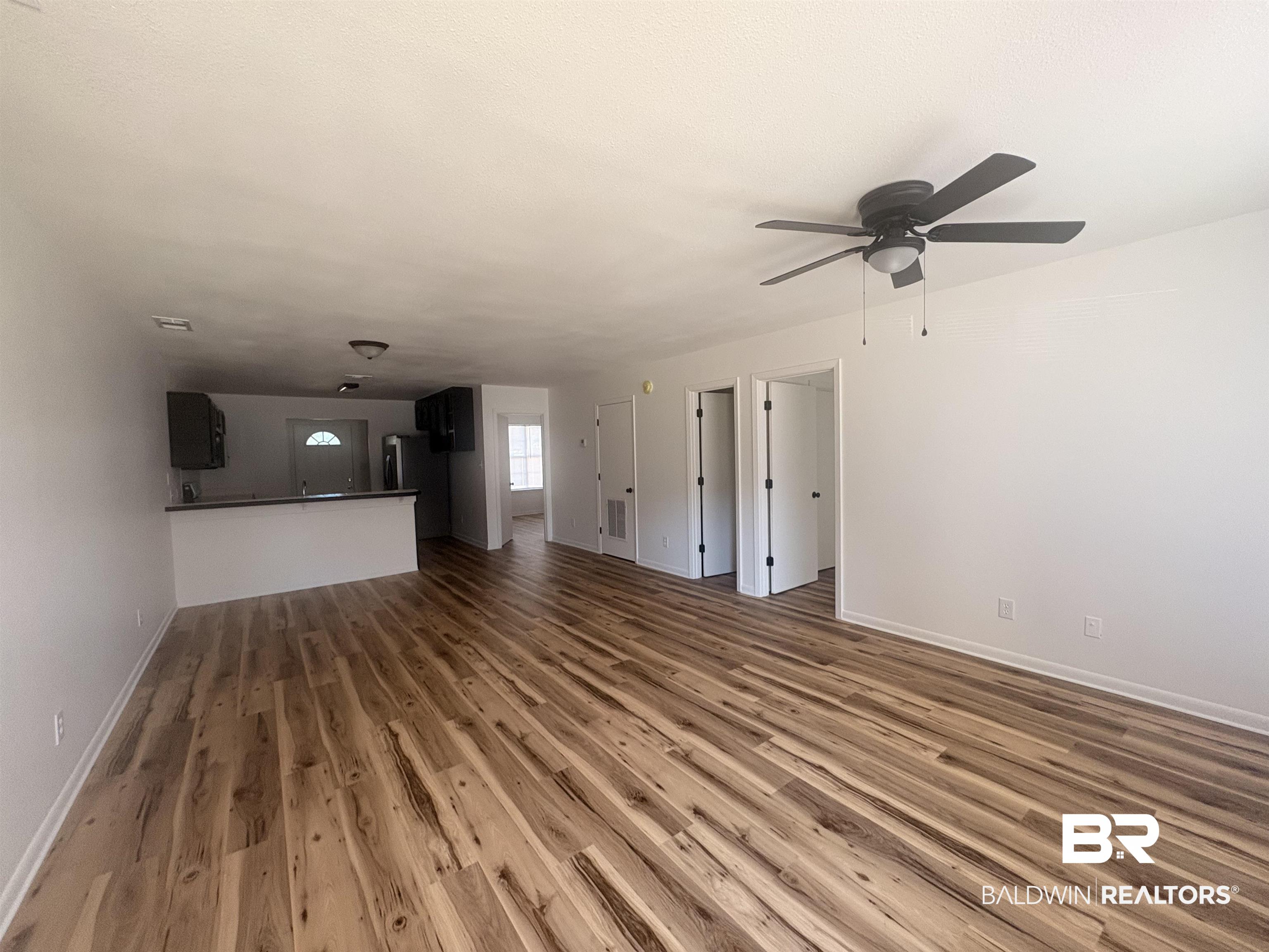 109-111 North Beech Street, Unit A & B Foley, AL 36535 - Photo 3 of 16 Unfurnished living room featuring dark wood-type flooring and a ceiling fan