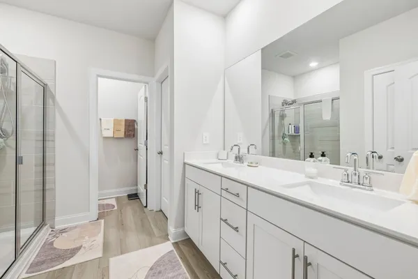 a bathroom with a double vanity sink mirror and shower