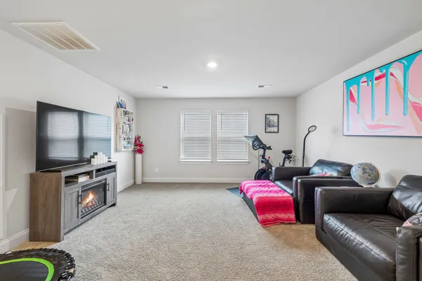 a living room with furniture a flat screen tv and a window