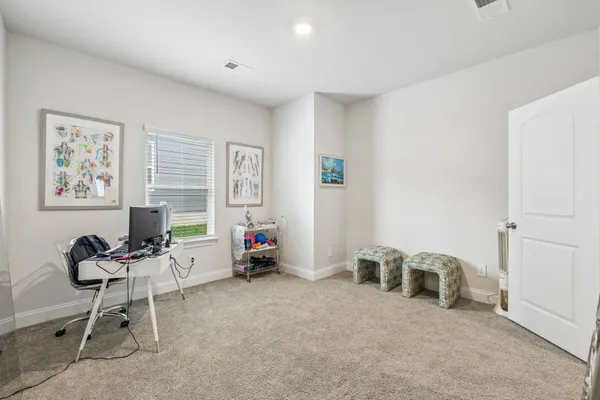 a view of workspace with lounge chair and windows