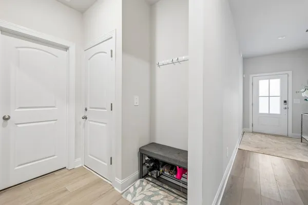 a view of a hallway with wooden floor and closet area