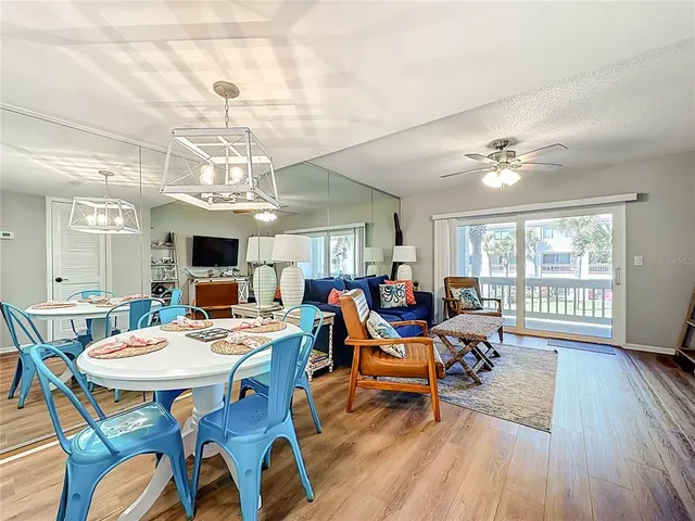 a view of a dining room with furniture a chandelier and wooden floor