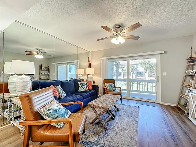 a living room with furniture a ceiling fan and a window
