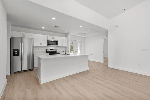 a view of kitchen with granite countertop cabinets and refrigerator