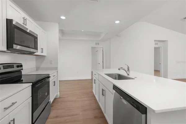 a kitchen with stainless steel appliances granite countertop a sink and a stove