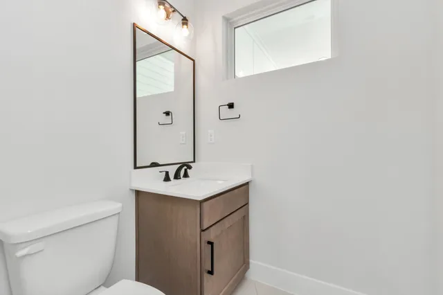 a bathroom with a sink a toilet and mirror