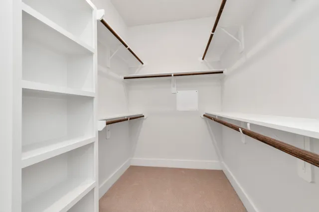 a view of walk in closet with empty racks