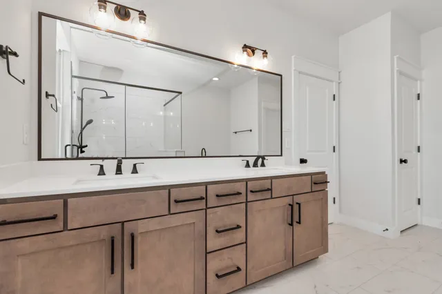 a bathroom with a double vanity sink and mirror