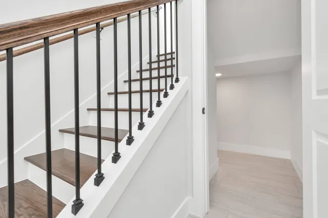 a view of staircase with lots of frames on wall and a window