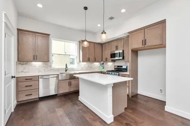 a kitchen with stainless steel appliances granite countertop a sink stove and refrigerator
