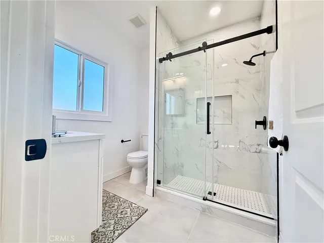 a bathroom with a shower a toilet and sink