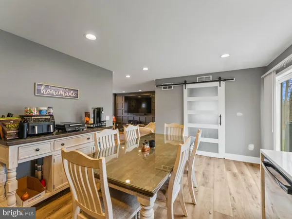 a view of a dining room with furniture a kitchen and chandelier