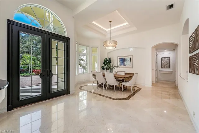 a view of a dining room with furniture a chandelier and wooden floor