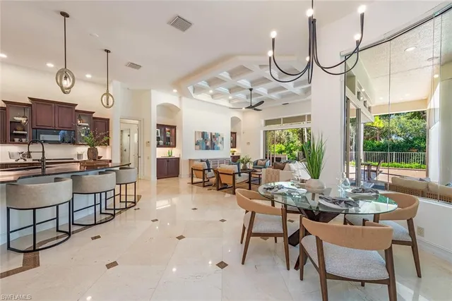 a view of a dining room and livingroom with furniture wooden floor a chandelier