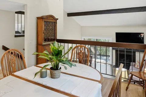 a view of a dining room with furniture a potted plant and wooden floor