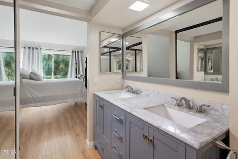 a bathroom with a granite countertop sink and a large mirror