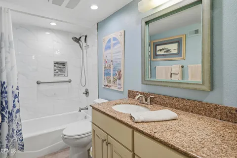 a bathroom with a granite countertop sink toilet and a bathtub