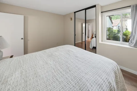 a large white bed in a bathroom next to a window