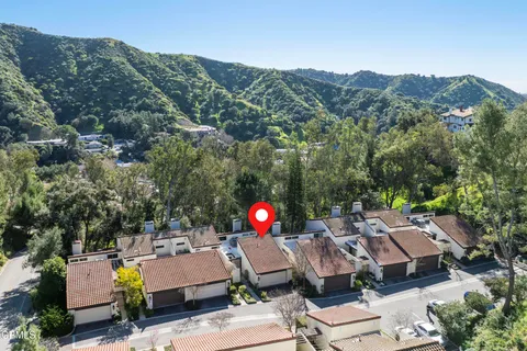 an aerial view of a house with swimming pool and mountains