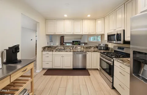 a kitchen with a sink stove top oven and cabinets