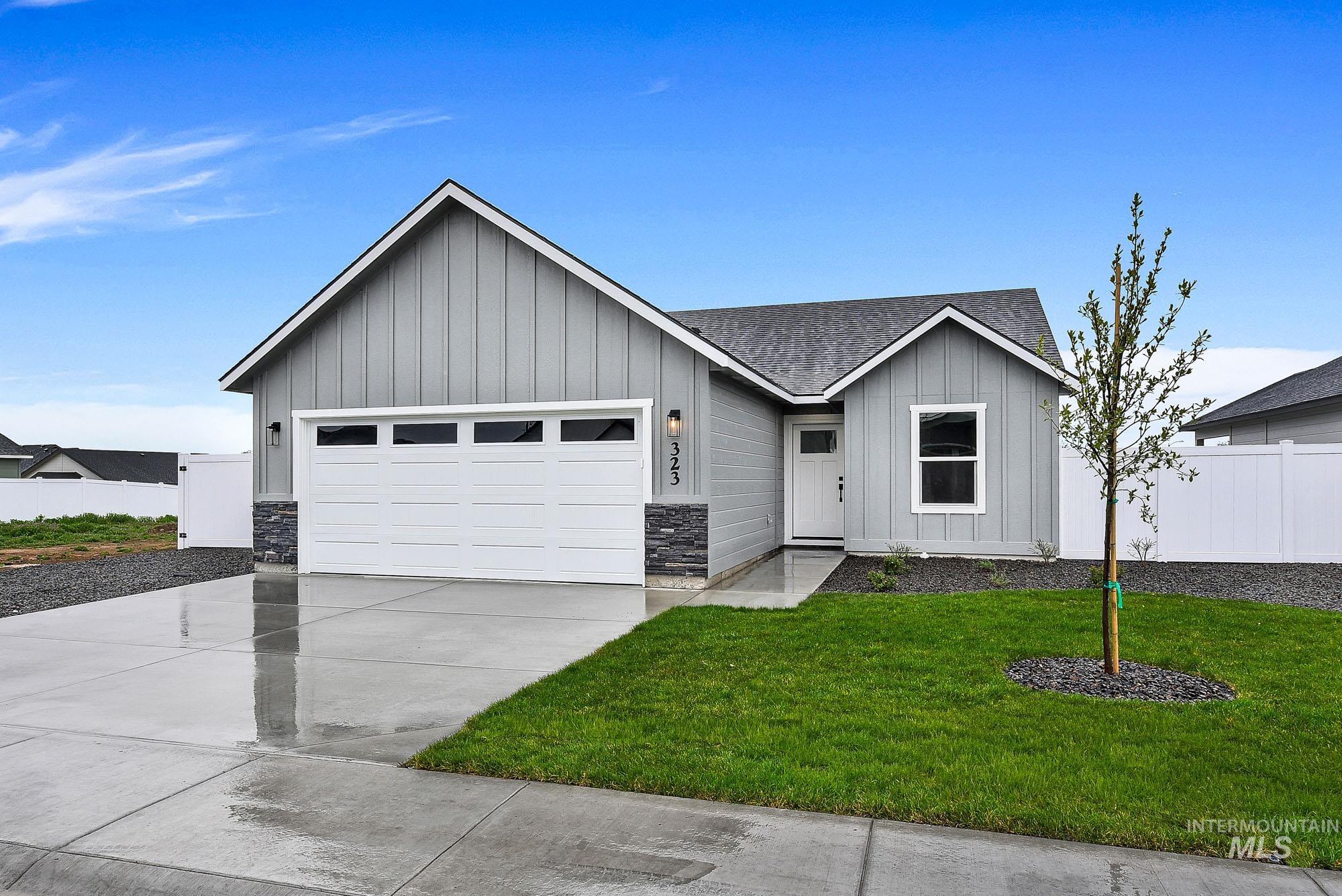 View of front of property featuring board and batten siding, a garage, driveway, a shingled roof, and stone siding