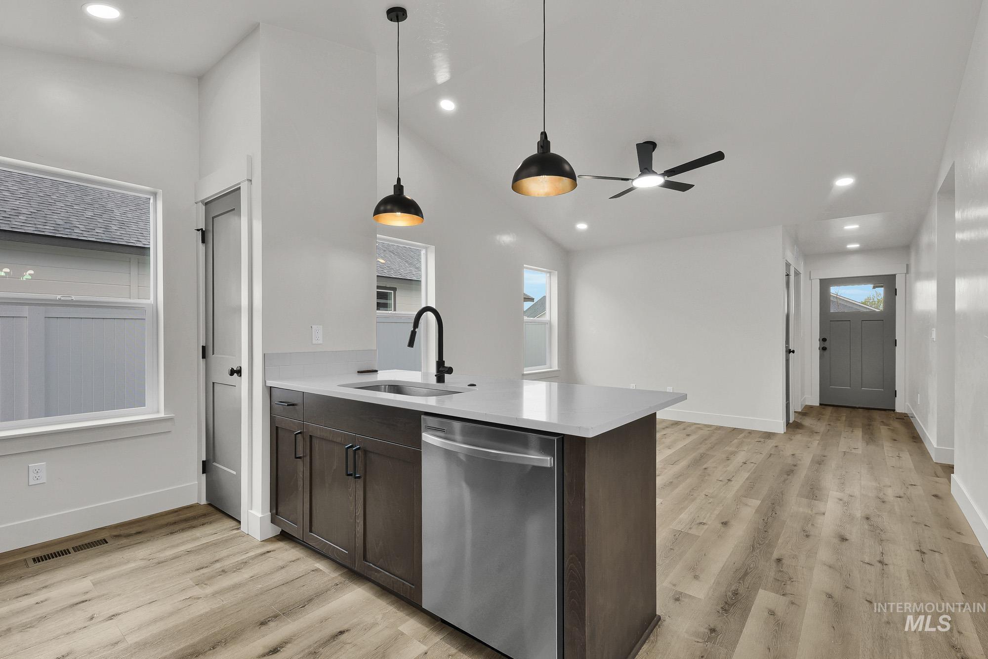 323 North 12th Street Parma, ID 83660 - Photo 13 of 28 Kitchen with a peninsula, stainless steel dishwasher, dark wood finish cabinetry, pendant lighting, and light wood finished floors