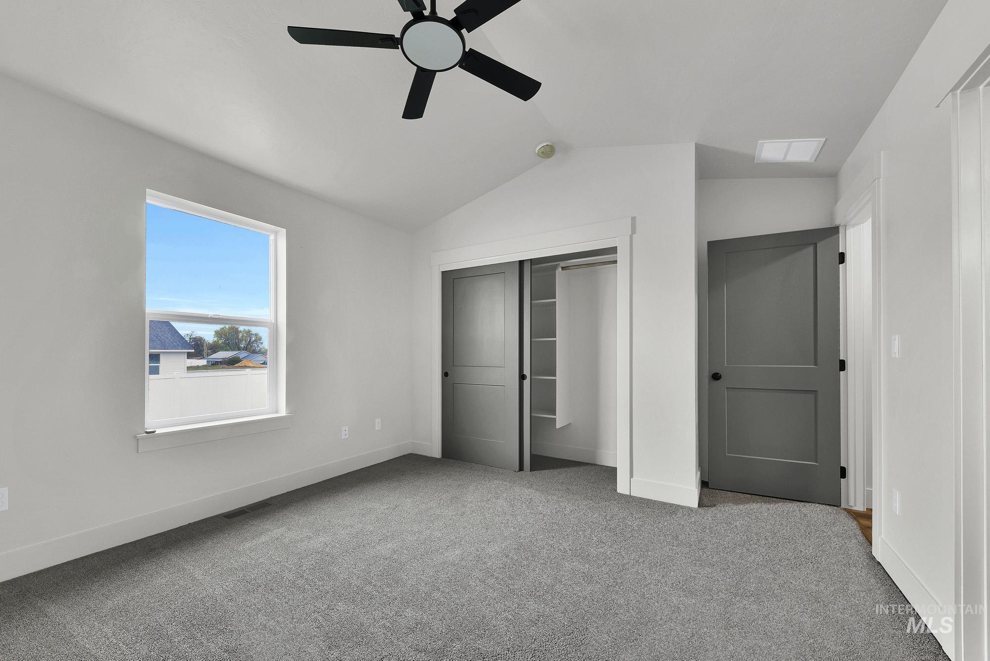 323 North 12th Street Parma, ID 83660 - Photo 14 of 28 Unfurnished bedroom featuring light carpet, lofted ceiling, a closet, and ceiling fan