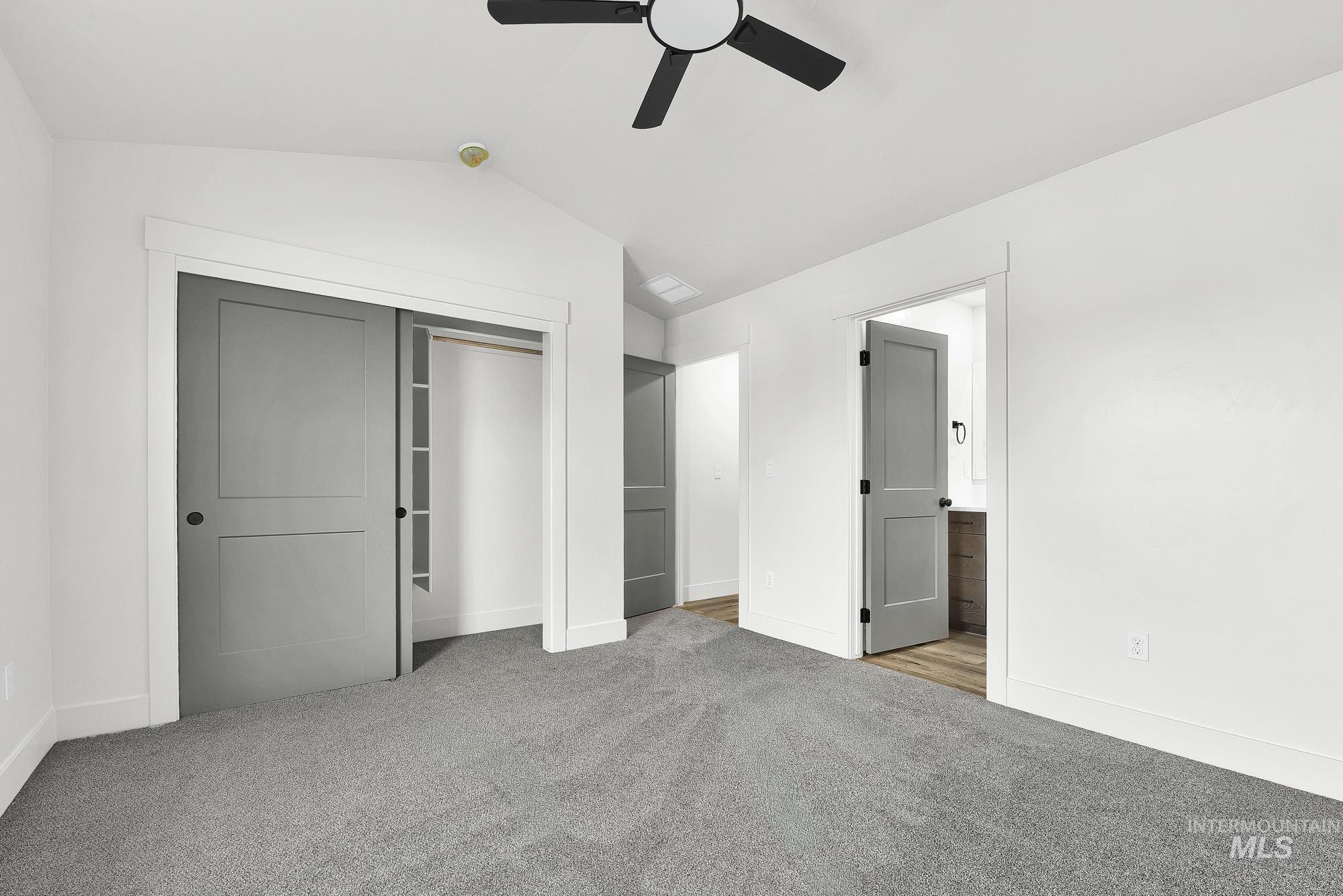 323 North 12th Street Parma, ID 83660 - Photo 15 of 28 Unfurnished bedroom with light colored carpet, lofted ceiling, a closet, connected bathroom, and ceiling fan