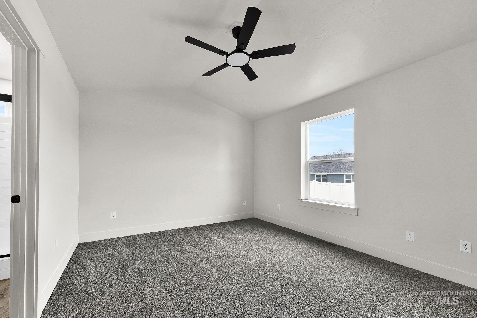 323 North 12th Street Parma, ID 83660 - Photo 16 of 28 Empty room featuring dark colored carpet, lofted ceiling, and a ceiling fan