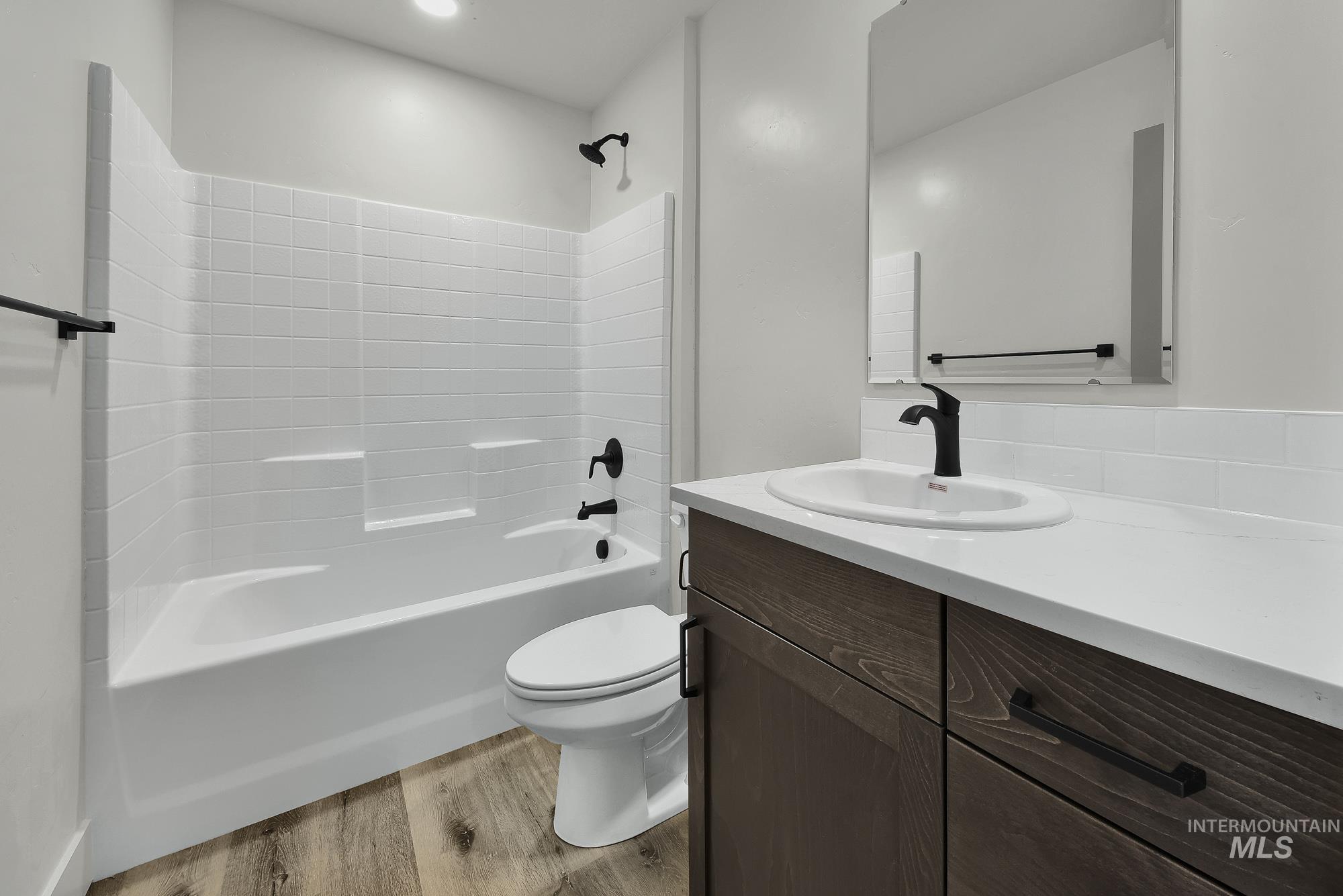 323 North 12th Street Parma, ID 83660 - Photo 17 of 28 Full bathroom featuring vanity, light wood-style flooring, and shower combination