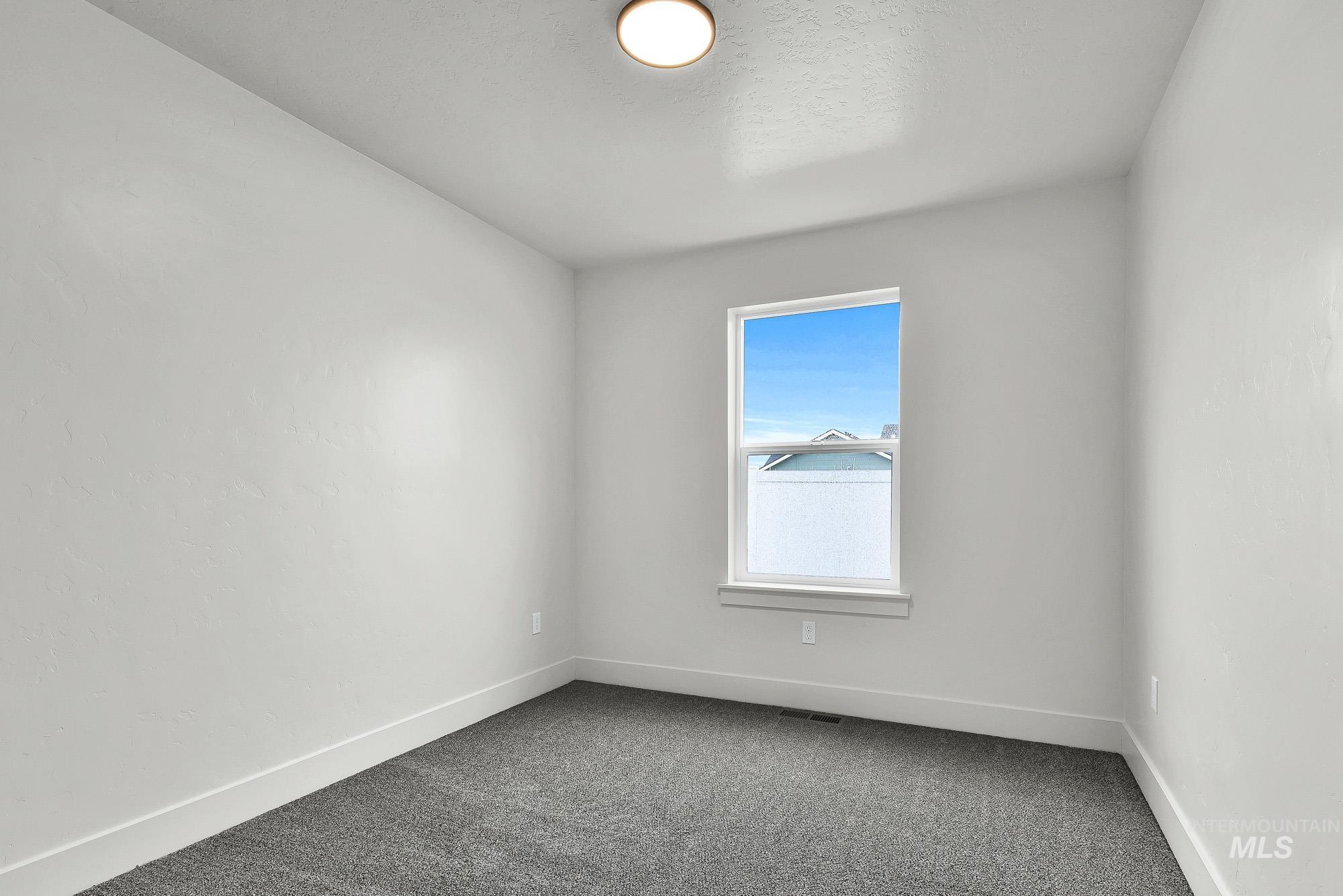 323 North 12th Street Parma, ID 83660 - Photo 21 of 28 Empty room with dark carpet and baseboards