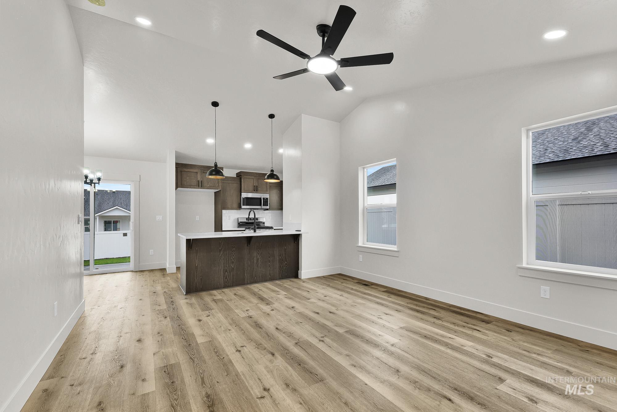 323 North 12th Street Parma, ID 83660 - Photo 28 of 28 Kitchen featuring open floor plan, light wood-type flooring, decorative light fixtures, ceiling fan, and a peninsula