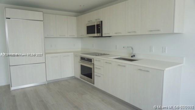 55 Southwest 9th Street, Unit 3307 Miami, FL 33130 - Photo 2 of 16 a view of a kitchen with white cabinets and white appliances