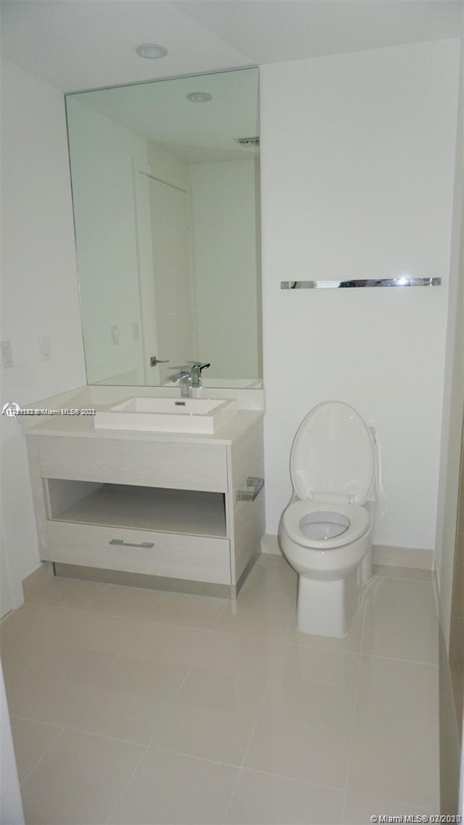 55 Southwest 9th Street, Unit 3307 Miami, FL 33130 - Photo 8 of 16 a bathroom with a toilet a sink and mirror
