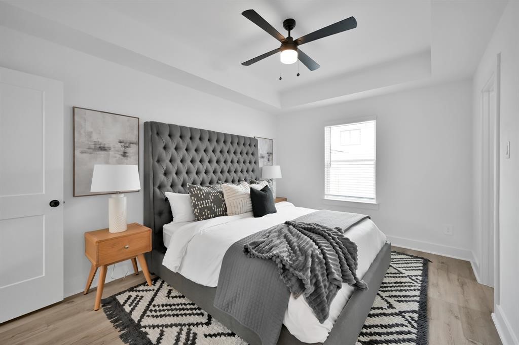 8019 Cora Street, Unit A Houston, TX 77088 - Photo 11 of 25 a bedroom with a bed and a chandelier