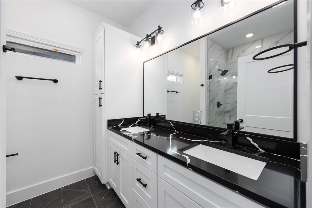 8019 Cora Street, Unit A Houston, TX 77088 - Photo 14 of 25 a bathroom with a granite countertop sink a mirror and a shower