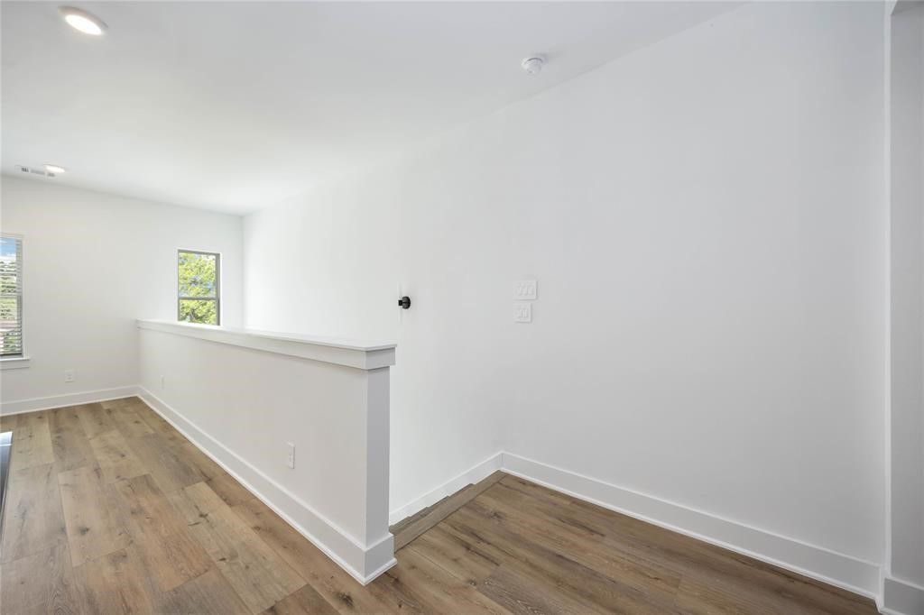 8019 Cora Street, Unit A Houston, TX 77088 - Photo 5 of 25 an empty room with wooden floor and windows