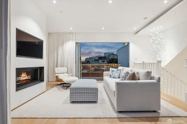 a living room with furniture a large window and a fireplace