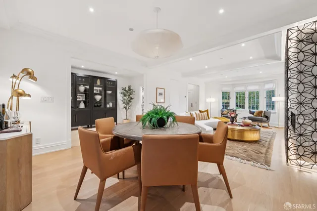 a living room with furniture a wooden floor and a view of kitchen