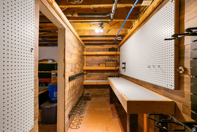 615 East Maple Street Mapleton, UT 84664 - Photo 21 of 30 hidden work room with wood-finish wall paneling, exposed ceiling joists, and a built-in workbench featuring a light-colored surface
