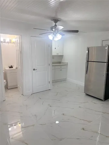 a view of a kitchen with cabinet and a refrigerator